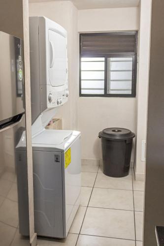 a small kitchen with a washer and dryer at Central apartment near IMSS, H. Civil and CUCS in Guadalajara
