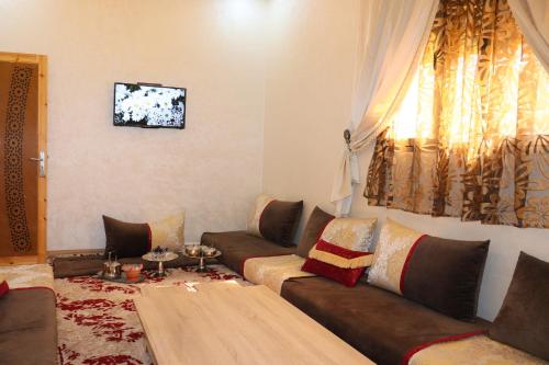 ein Wohnzimmer mit Sofa und Tisch in der Unterkunft Bel appartement-Haut débit WIFI in El Aaiún