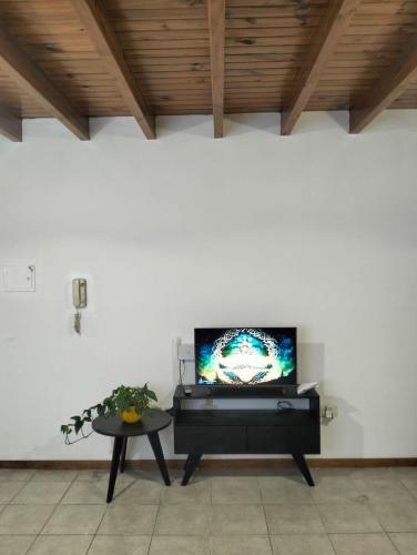 a living room with a tv and a table at Cómodo Departamento 2 Ambientes in Guaymallen