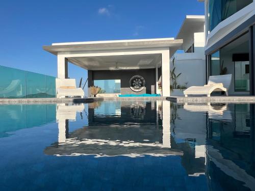a villa with a swimming pool in front of a house at Villa Best View Samui managed by Villa For You in Koh Samui 