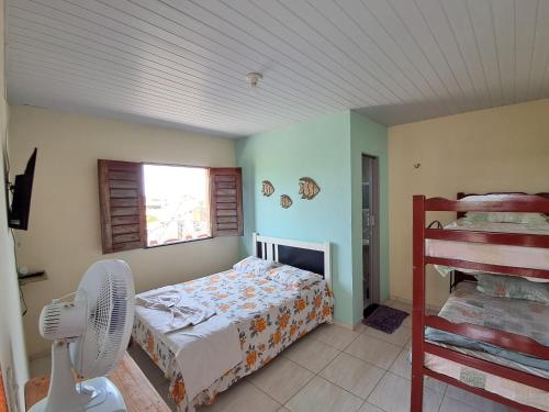 sypialnia z łóżkiem, wentylatorem i oknem w obiekcie Cantinho da Tia Lucia w mieście Beberibe