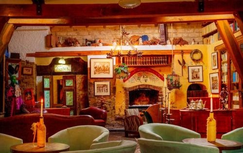 a living room with a fireplace and tables and chairs at Hotel La Posada de San Antonio in Villa de Leyva