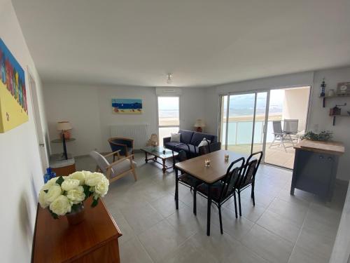 un salon avec une table et des chaises dans l'établissement Appartement Neuf 3/4 Couchages à 30m de la Plage avec Parking - FR-1-364-161, à Saint-Brévin-les-Pins