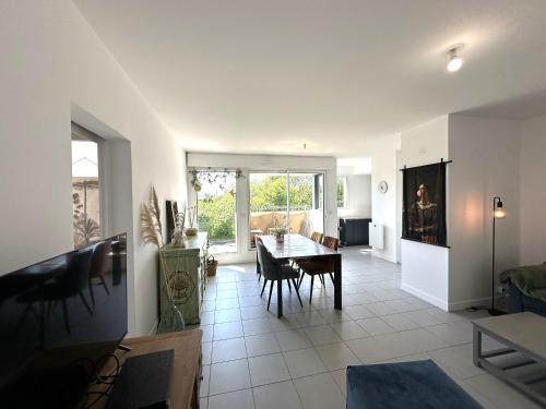 un salon avec une table et une salle à manger dans l'établissement Élégant appartement à Fouras: proche centre-ville et plage avec terrasse et balcon - FR-1-709-73, à Fouras