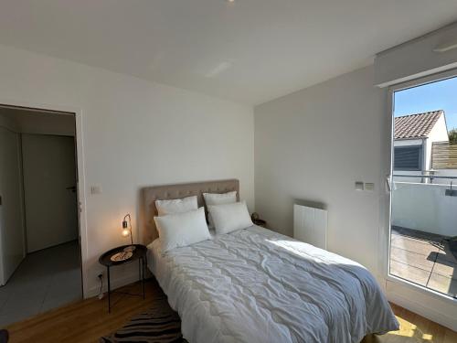 une chambre avec un lit et une grande fenêtre dans l'établissement Élégant appartement à Fouras: proche centre-ville et plage avec terrasse et balcon - FR-1-709-73, à Fouras