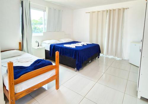 a bedroom with two beds and a window at Pousada Maresia Unique Beira Mar in Porto De Galinhas