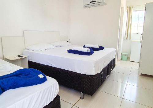 two beds in a room with white walls at Pousada Maresia Unique Beira Mar in Porto De Galinhas