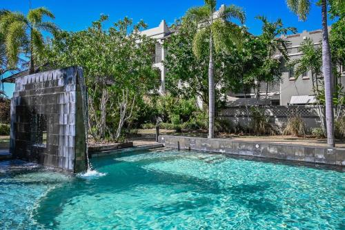 a pool with blue water in front of a house at Tropical Gardens - Resort 9 Pools free parking in Cairns