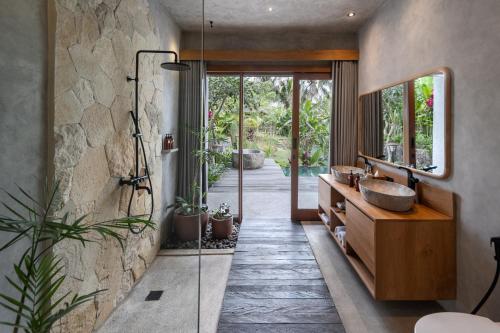 a bathroom with a sink and a mirror at Inara Alas Harum in Ubud