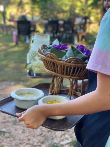 a woman standing in front of a picnic table with food at Baan Siri in Ban Dong Bang