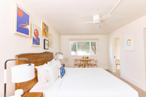 a white bedroom with a bed and a table at Laguna Surf Lodge by SCP Hotels in Laguna Beach