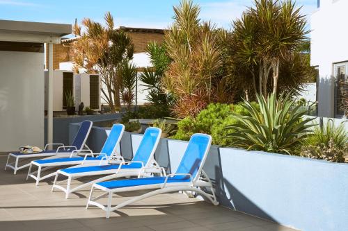 a row of blue and white chairs on a patio at Centrepoint Apartments Caloundra in Caloundra