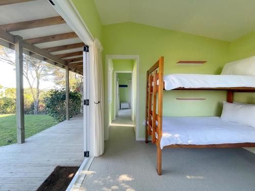 Ένα ή περισσότερα κρεβάτια σε δωμάτιο στο Genuine Kiwi Bach- Stay Waiheke