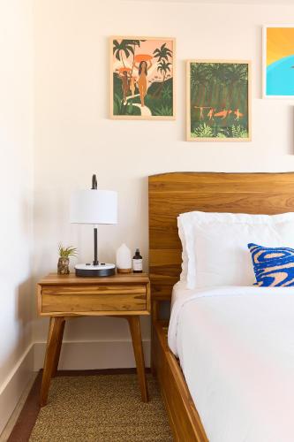 a bedroom with a bed and a table with a lamp at Laguna Surf Lodge by SCP Hotels in Laguna Beach
