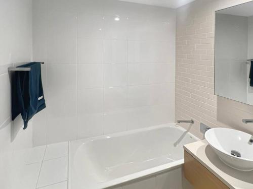 a bathroom with a white tub and a sink at Welcome Homestay Waterfront in Darwin