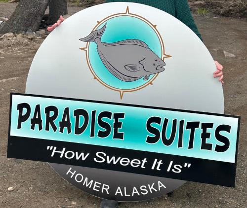 a person holding a surfboard with a sign that reads paradise surfers how sweet at Paradise Suites The Wolf Den in Homer