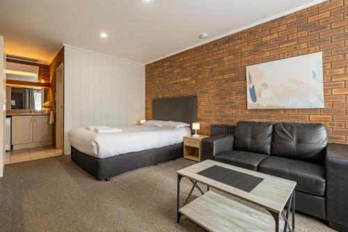 旺萨吉Wonthaggi Motel的配有床和沙发的酒店房间