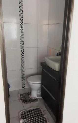 a small bathroom with a sink and a toilet at Casa com piscina in Cianorte