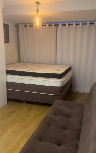 a bedroom with a bed and a couch at Casa com piscina in Cianorte