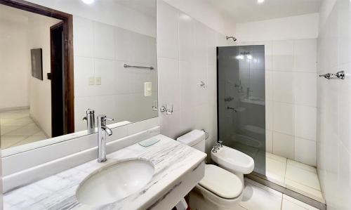 ein weißes Bad mit einem Waschbecken und einem WC in der Unterkunft Tiny Houses en Asunción. Zona Aeropuerto-Rakiura in Zarate Isla