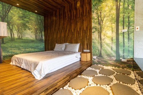 a bedroom with a bed with a mural of a forest at 宜蘭頭城溫泉海景無邊際泳池豪華套房 in Hsin-hsing