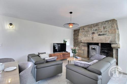 a living room with two couches and a fireplace at Kergonet in Plougrescant
