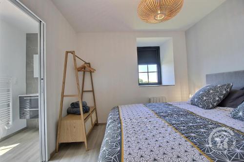 a bedroom with a bed and a ladder and a window at Kergonet in Plougrescant