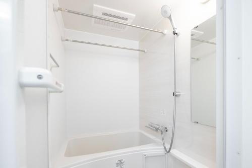 a white bathroom with a shower and a sink at aLATO Omorimachi in Tokyo