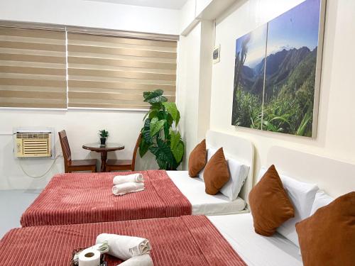 a hotel room with two beds and a table at Casa Bicolandia Suites in Daraga