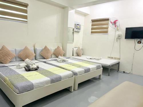 a hospital room with two beds and a tv at Casa Bicolandia Suites in Daraga