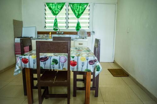 a kitchen with a table and chairs with a tablecloth on it at Philomena's Lodge in Douane