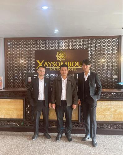 three men in suits standing in front of a building at Xaysomboun Hotel & SPA in Vientiane