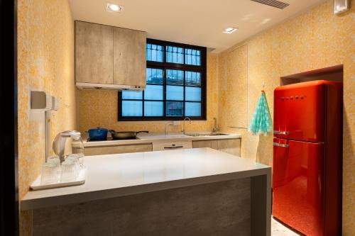 uma cozinha com um frigorífico vermelho e uma janela em 文坊 Wen Guest House em Taipei