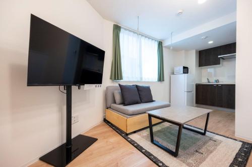 a living room with a couch and a flat screen tv at MAT Nogata in Tokyo