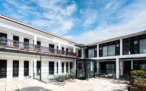 an exterior view of a white building with a patio at Lijiang Gemmer Hotel in Lijiang