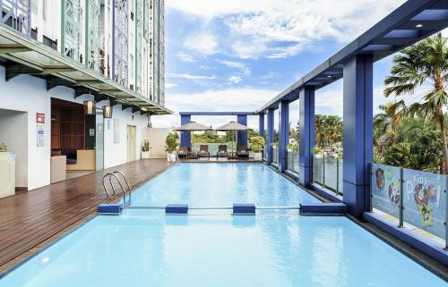 a large swimming pool in a building with windows at Swiss-Belinn Modern Cikande in Serang