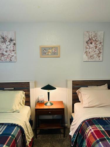 a bedroom with two beds and a table with a lamp at Emerald City 3 Bedroom 1 bath Home in Eugene