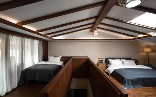 a bedroom with two beds and a window at Lijiang Gemmer Hotel in Lijiang