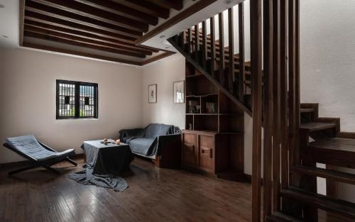 a living room with a staircase and a couch at Lijiang Gemmer Hotel in Lijiang