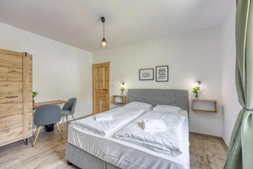 a bedroom with a white bed and a desk and a chair at VILA LISJAK - Apartments in Podčetrtek