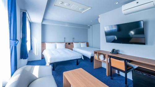 a hotel room with two beds and a desk at Toyoko Inn Nagasaki Ekimae in Nagasaki