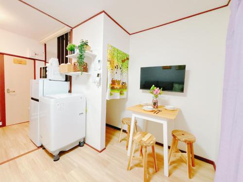a small kitchen with a small table and a white refrigerator at Ikebukuro area, two layer house, double subway,3 min walk to stn, 双地铁车站步行3分 直达新宿 涩谷 银座 池袋 皇居 最大6人 in Tokyo