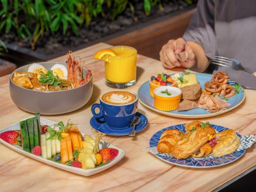 a table topped with plates of food and drinks at InterContinental Singapore Robertson Quay by IHG in Singapore