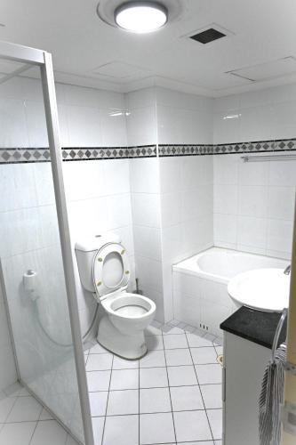 a white bathroom with a toilet and a sink at Resort Style 2BR Apt in Pyrmont Next to Darling Harbour in Sydney