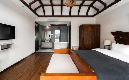a bedroom with a large bed and a bathroom at Lijiang Gemmer Hotel in Lijiang