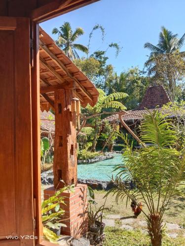 a view of a resort with a river in the background at Villa Mak Cik in Yogyakarta
