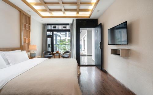 a bedroom with a bed and a tv on a wall at Lijiang Gemmer Hotel in Lijiang