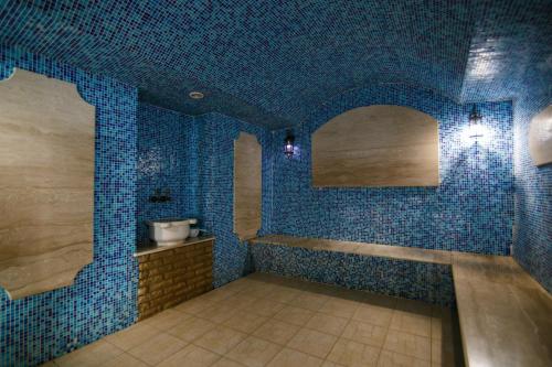 baño con paredes de azulejos azules y lavabo en Hotel Complex Bukhta Mechty, en Laspi