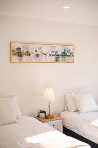 two beds in a room with a picture on the wall at StayAU Family Group 6BR Oasis Sanctuary Lakeview in Point Cook