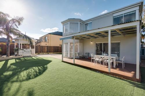 a house with a large backyard with a lawn at StayAU Family Group 6BR Oasis Sanctuary Lakeview in Point Cook